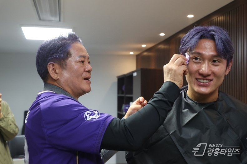 최대호 안양시장(왼쪽)이 11일 오전 FC안양 단장실에서 함께 머리를 보라색으로 염색한 김동진 FC안양 선수(오른쪽)의 얼굴을 닦아주고 있다