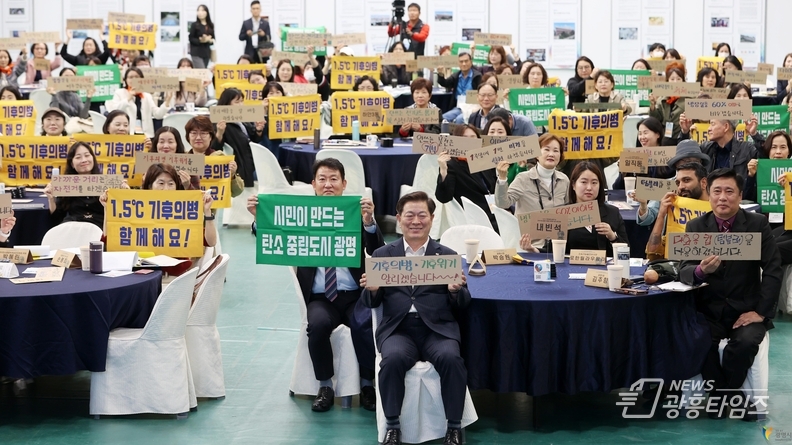 박승원 광명시장이 2024년 11월 광명남초등학교를 방문해 초등학생들과 광명시의 탄소중립 정책에 대해 소통하고, 자신만의 탄소중립 실천 방법을 작성한 종이를 들고 기념사진을 촬영하고 있다.