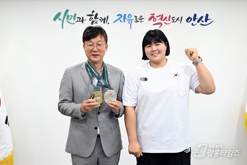 이민근 안산시장(왼쪽)이 1일 김하윤 선수(오른쪽)로부터 메달을 전달받고 함께 기념촬영을 하고 있다.