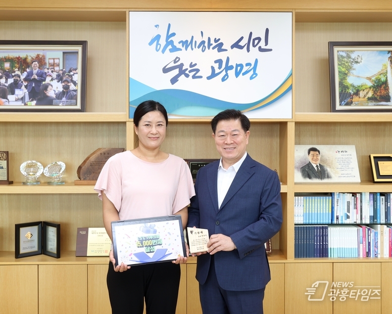 박승원 광명시장(사진 오른쪽)이 21일 오전 시장실에서 1만 5천 번째 ‘1.5℃ 기후의병’ 가입자 최 모 씨(사진 왼쪽)를 만나 기념패를 전달하고 기념사진을 촬영하고 있다.